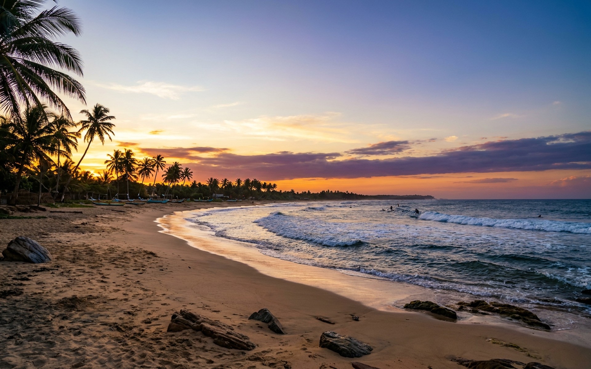 Surfers catching waves on the open ocean, with golden sandy beaches and palm trees lining the coast under a vibrant tropical sunset. at Arugam Bay, Sri Lanka — original Triple VIP destination visual.