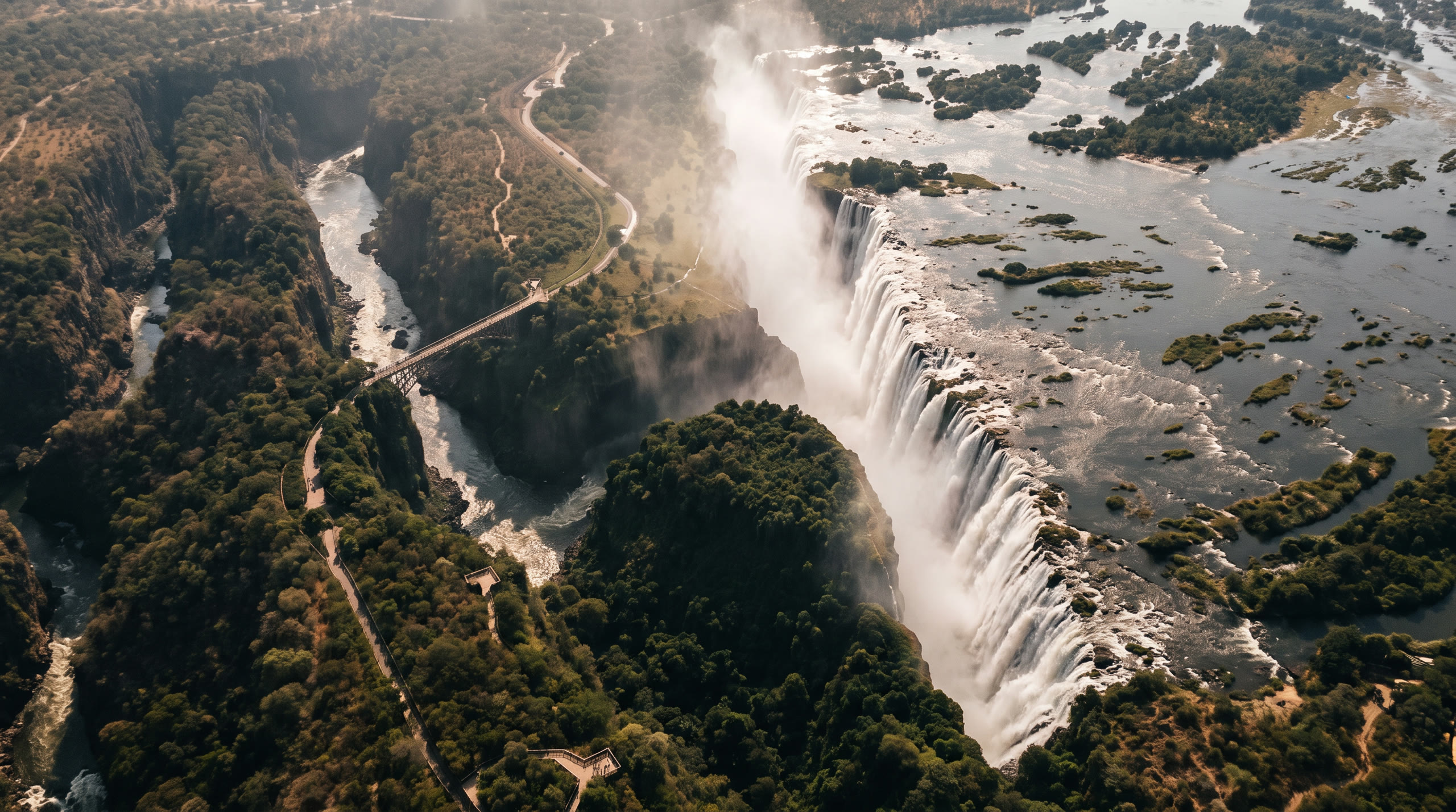 the full curtain of the falls plunging into the basalt gorge with spray rising at Victoria Falls, Zimbabwe, in mid-morning light — original Triple VIP destination visual.