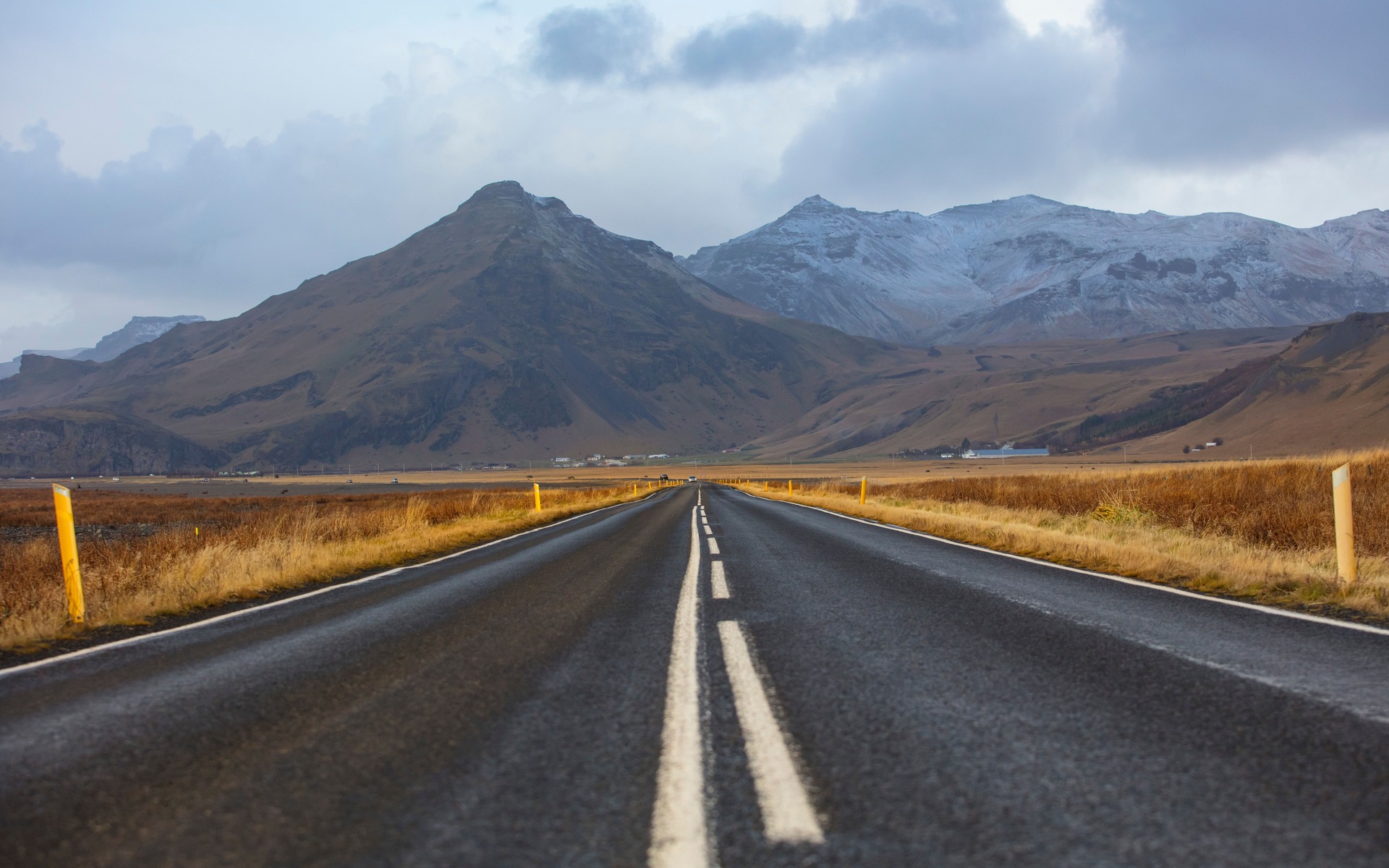 A long, empty road through a stunning mountain landscape in autumn, ideal for travel themes.