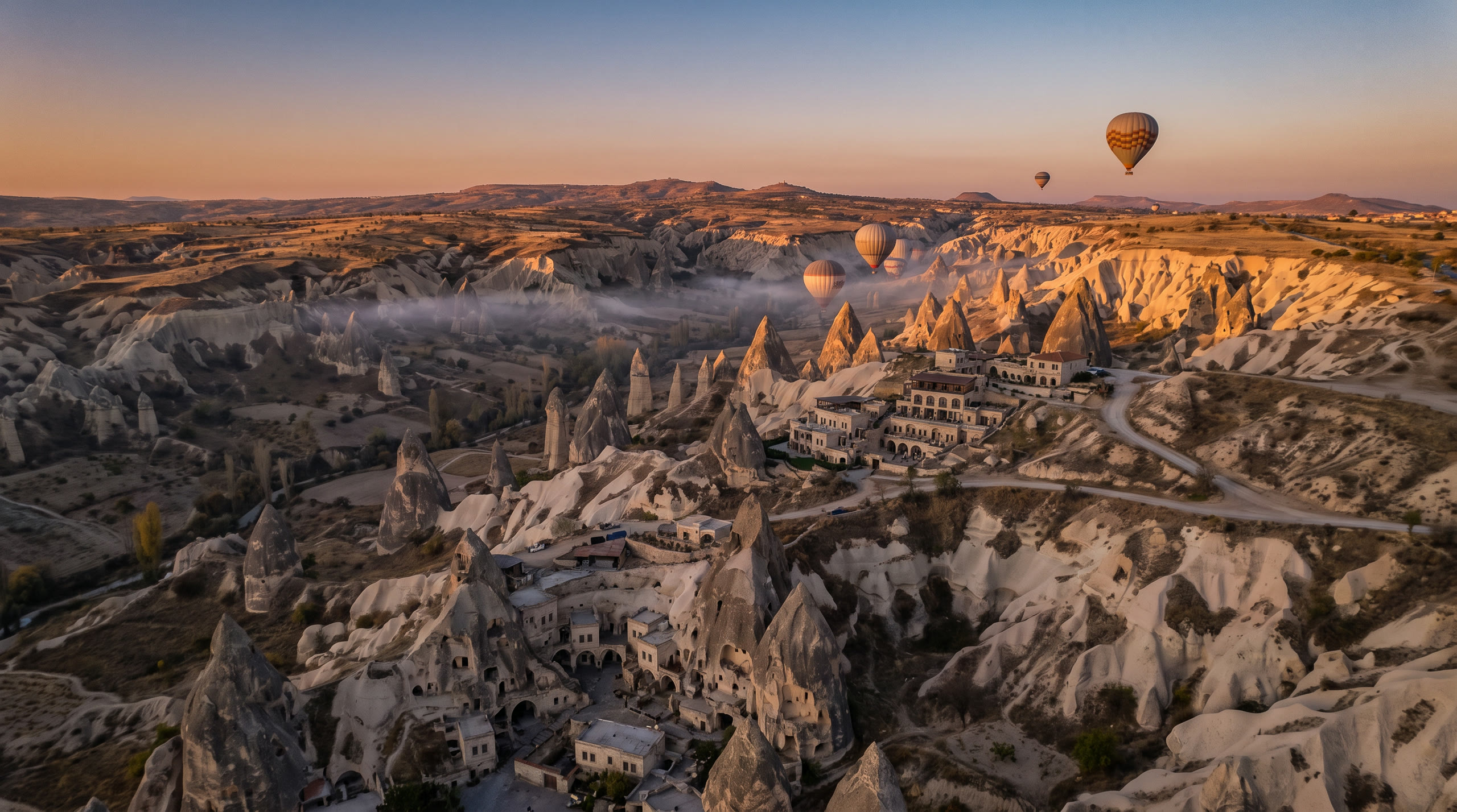 fairy-chimney rock formations across the Göreme valleys at dawn at Cappadocia, Turkey, in sunrise light — original Triple VIP destination visual.