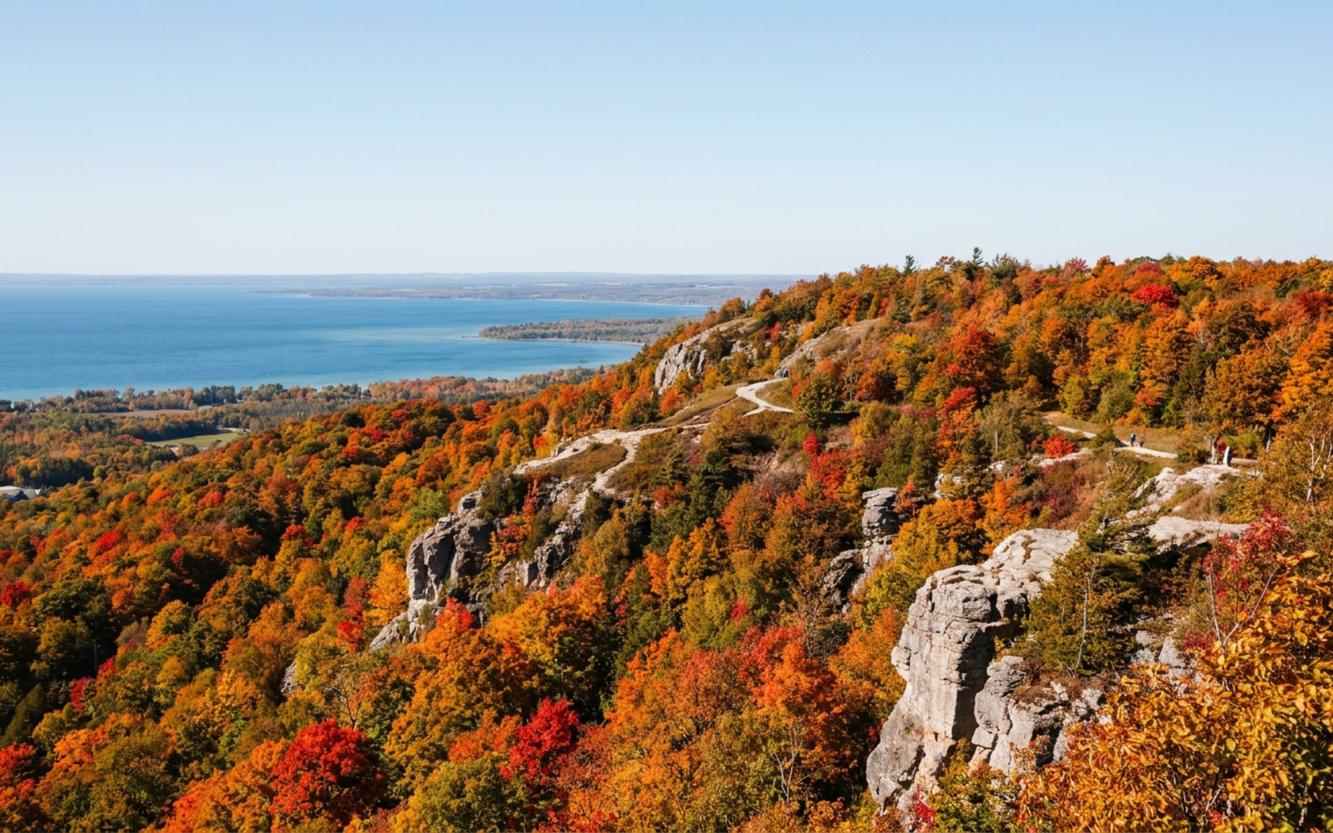 Vibrant autumn colours blanketing the slopes of Blue Mountain, Ontario, with a scenic view of Georgian Bay under a clear fall sky. at Blue Mountain, Ontario, Canada — original Triple VIP destination visual.
