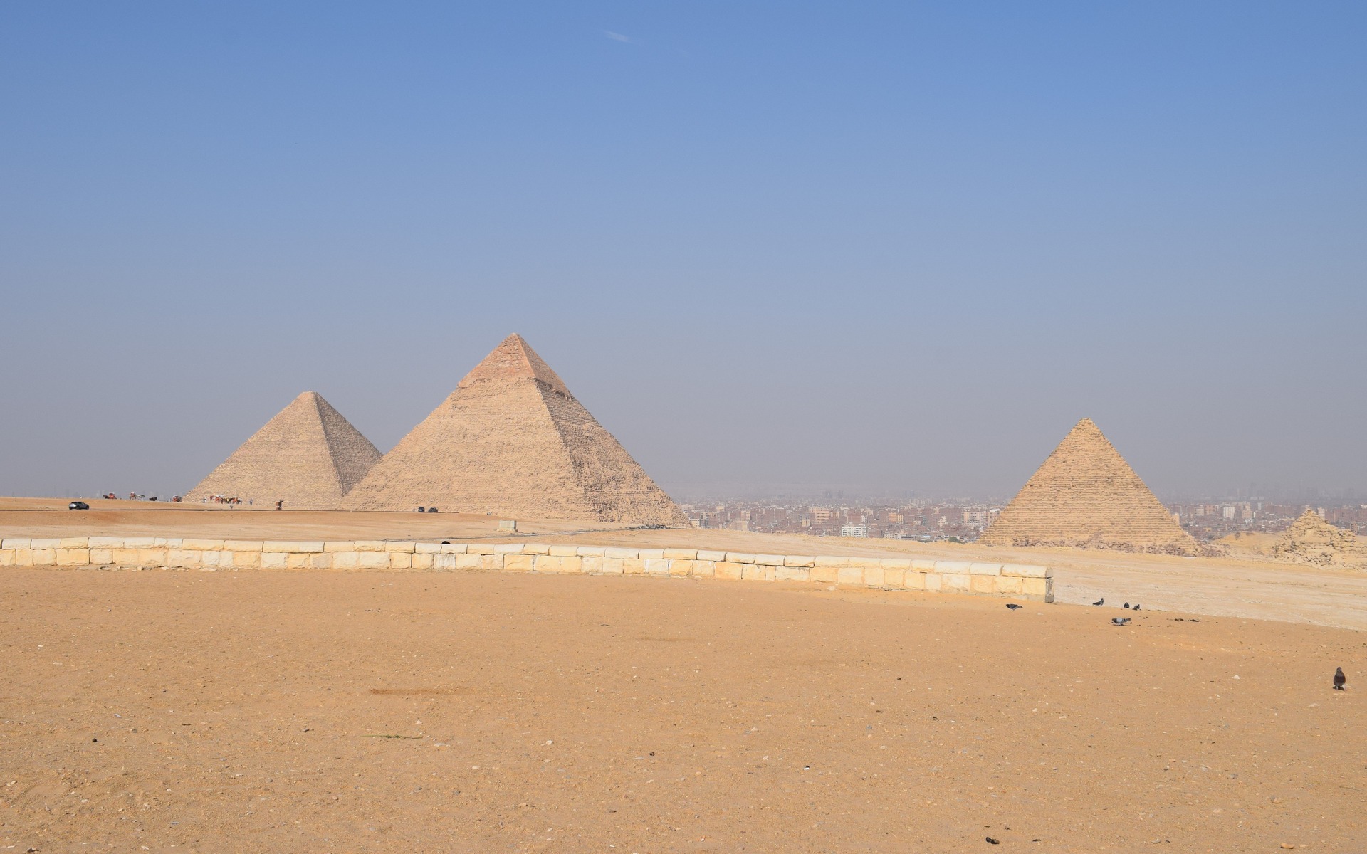 Breathtaking landscape of the Giza Pyramids under a clear blue sky in Cairo, Egypt.