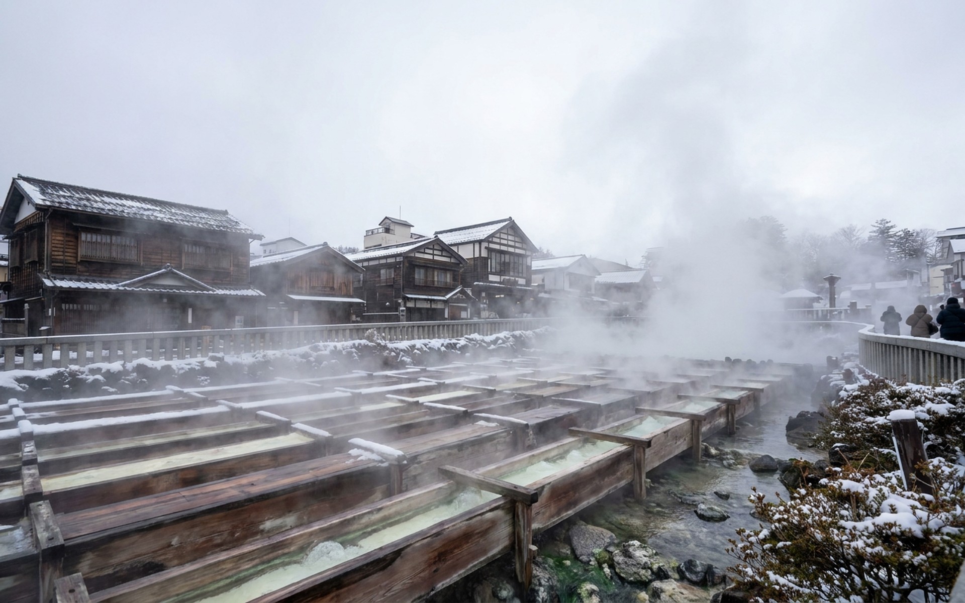 Steam rising dramatically from the iconic Yubatake hot spring source in Kusatsu Onsen town center, surrounded by traditional wooden buildings in winter. at Kusatsu Onsen, Japan — original Triple VIP destination visual.