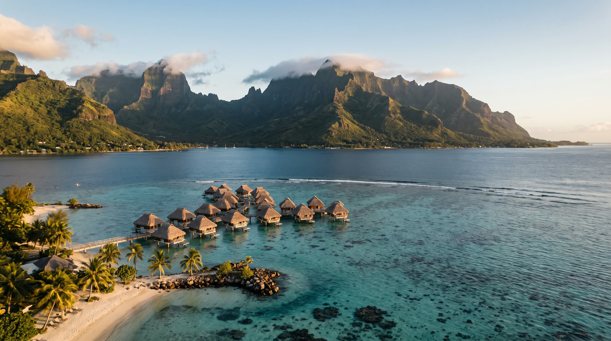 jagged volcanic peaks above a lagoon inside a barrier reef at Moorea & Tahiti, French Polynesia, in golden hour light — original Triple VIP destination visual.