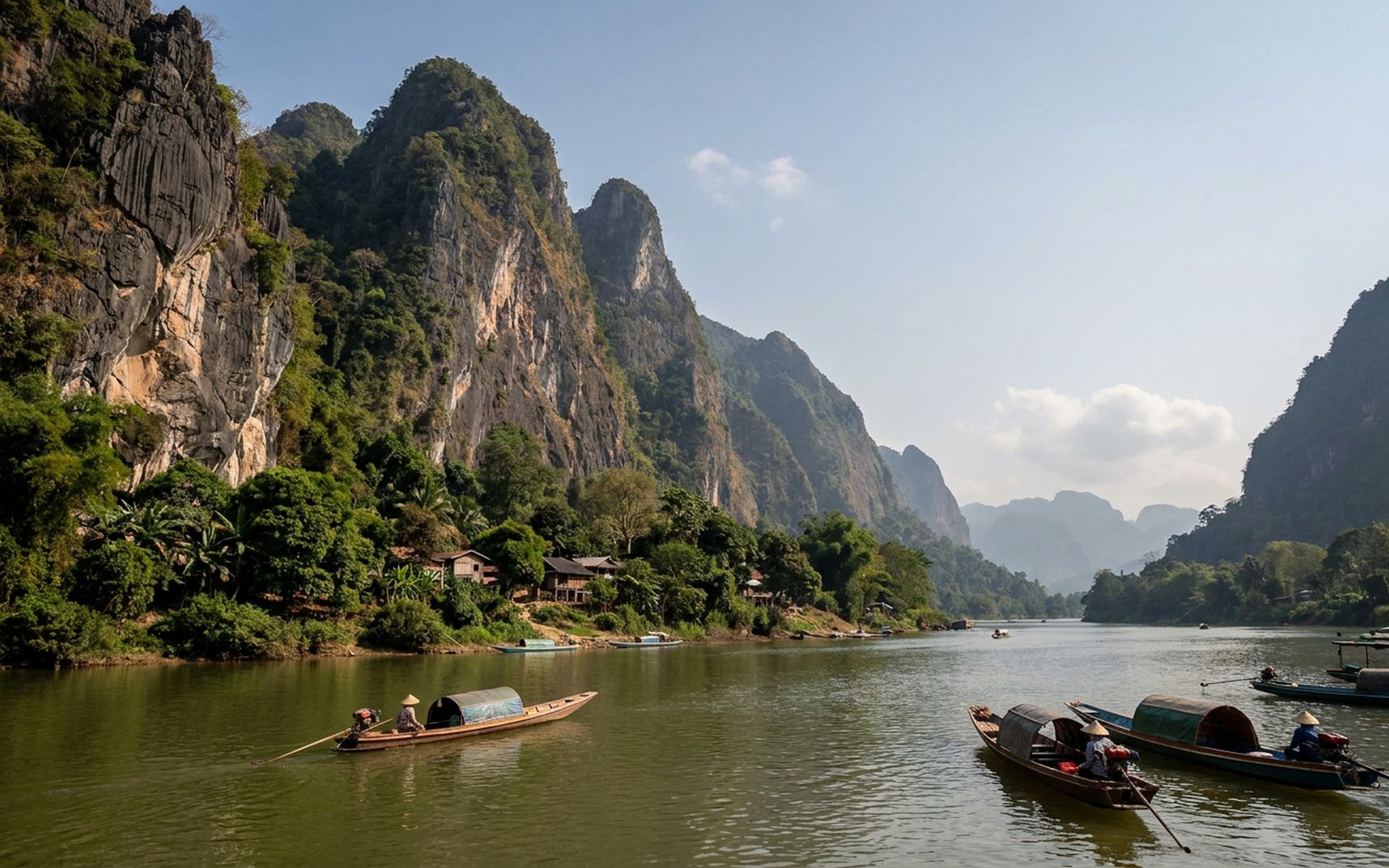 Towering limestone karsts rising majestically above the Nam Ou River, with traditional longtail boats navigating the calm waters in Nong Khiaw. at Nong Khiaw & Northern Laos, Laos — original Triple VIP destination visual.