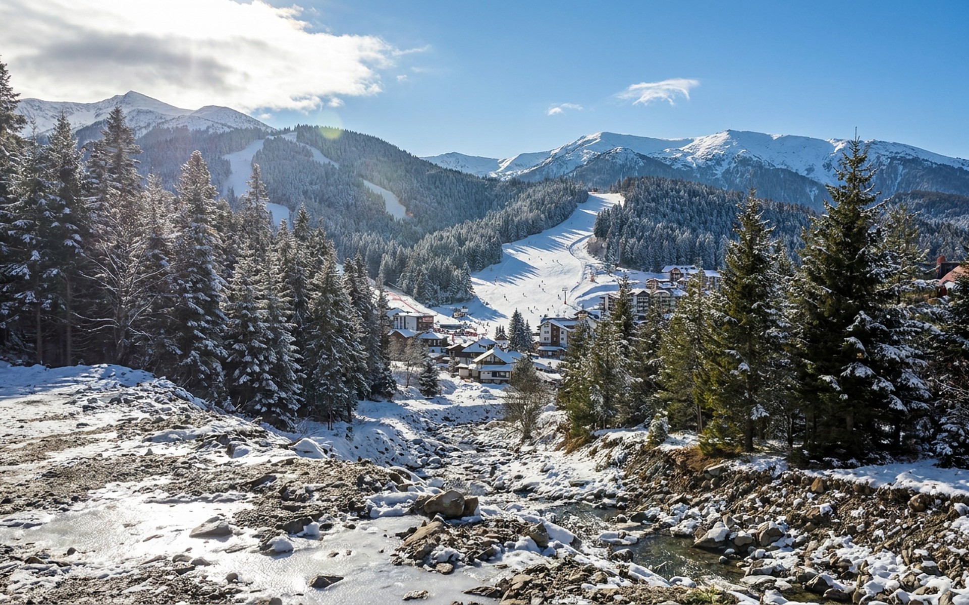 Sunlight glinting on snow-covered pine forests and ski slopes in the Rila Mountains surrounding the Borovets ski resort in winter. at Borovets, Bulgaria — original Triple VIP destination visual.