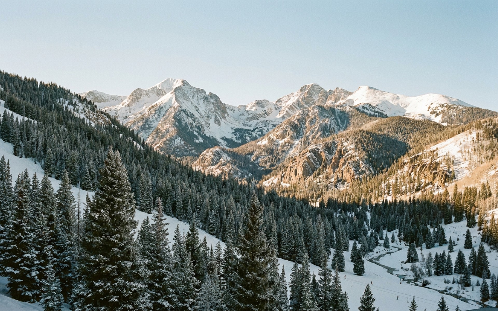 Snow-covered ski slopes and evergreen forests of Taos Ski Valley, with dramatic mountain peaks in the background under a bright winter sky. at Taos Ski Valley, United States — original Triple VIP destination visual.