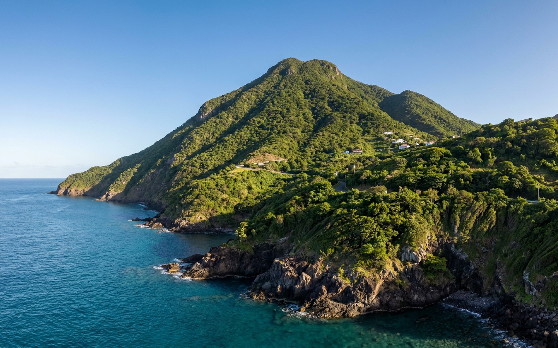 Lush green volcanic peak of Mount Scenery rising dramatically from the turquoise Caribbean Sea under a clear blue sky. at Saba & St Eustatius, Netherlands — original Triple VIP destination visual.