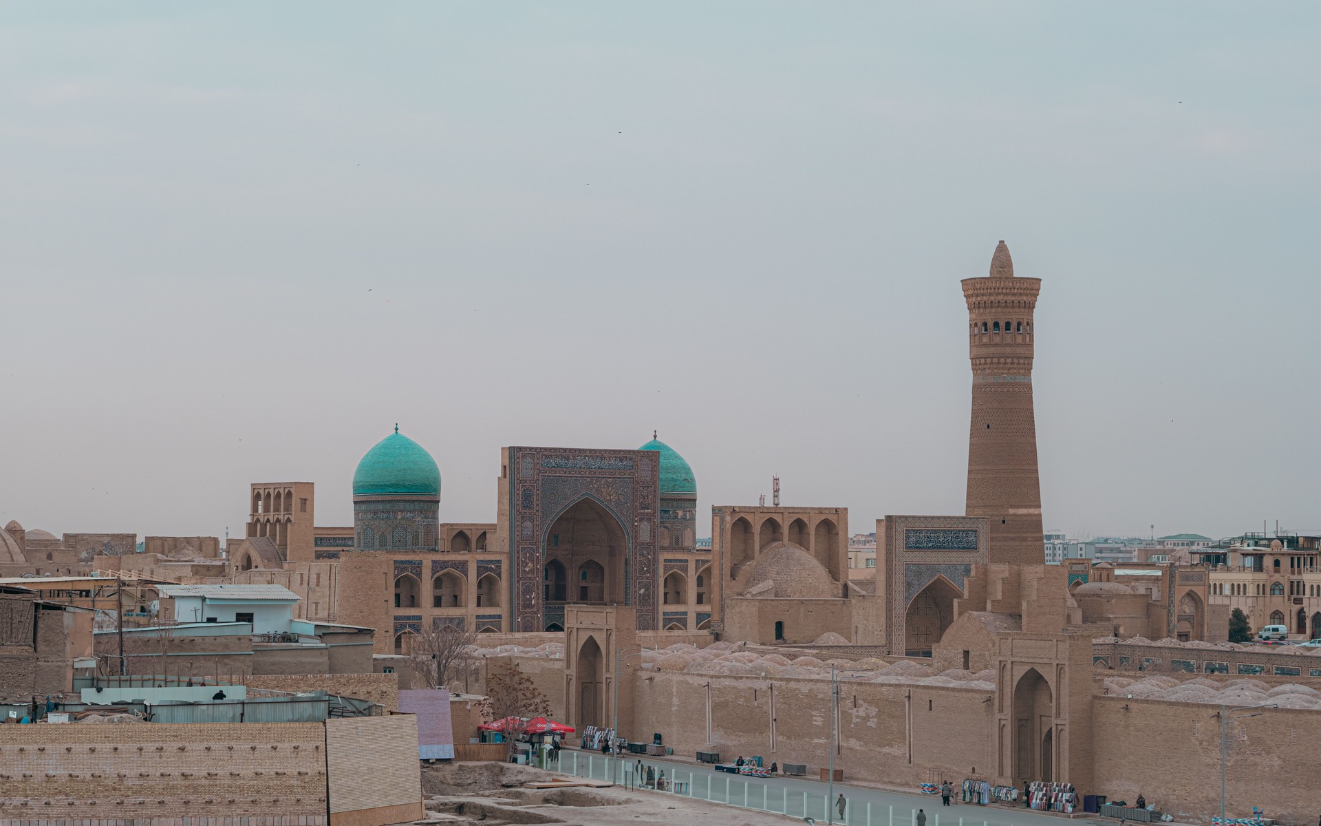 A scenic view of Bukhara's historic Kalyan Minaret and mosque at dusk, highlighting Central Asian architecture.