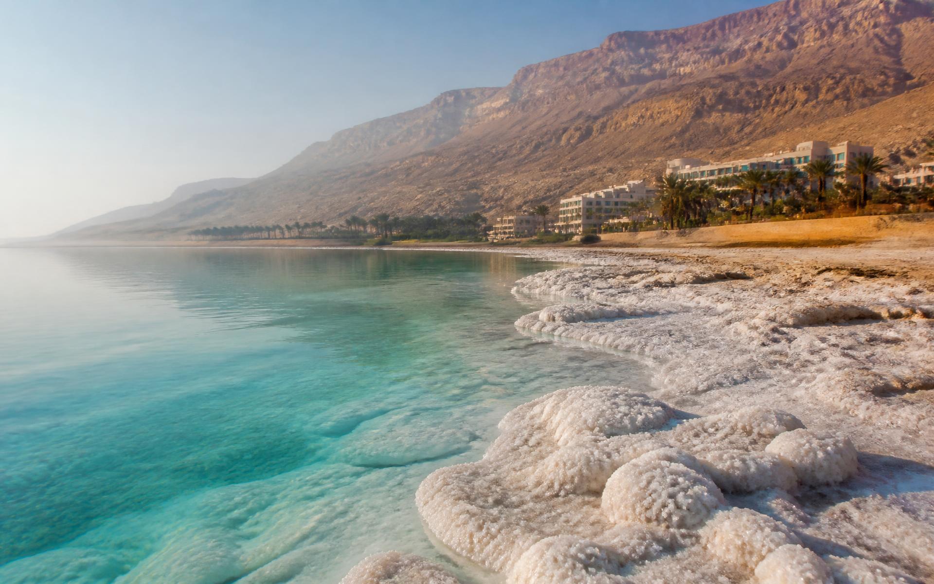 salt formations along a still mineral shoreline with desert hills beyond at the Dead Sea, Israel — original Triple VIP destination visual.