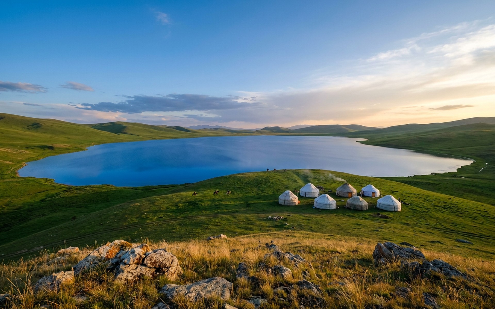 Traditional Kyrgyz yurts clustered on the emerald green pastures surrounding the serene, high-altitude alpine lake of Song-Köl under a vast sky. at Song-Köl, Kyrgyzstan — original Triple VIP destination visual.