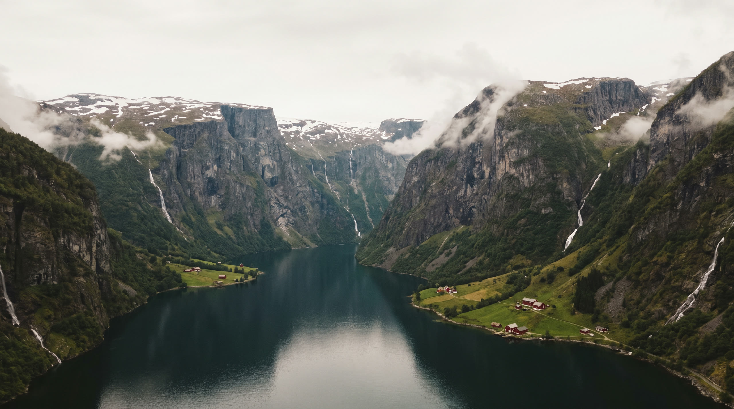 a deep fjord between near-vertical cliffs with waterfalls to the water at Norwegian Fjords, Norway, in soft overcast midday light — original Triple VIP destination visual.