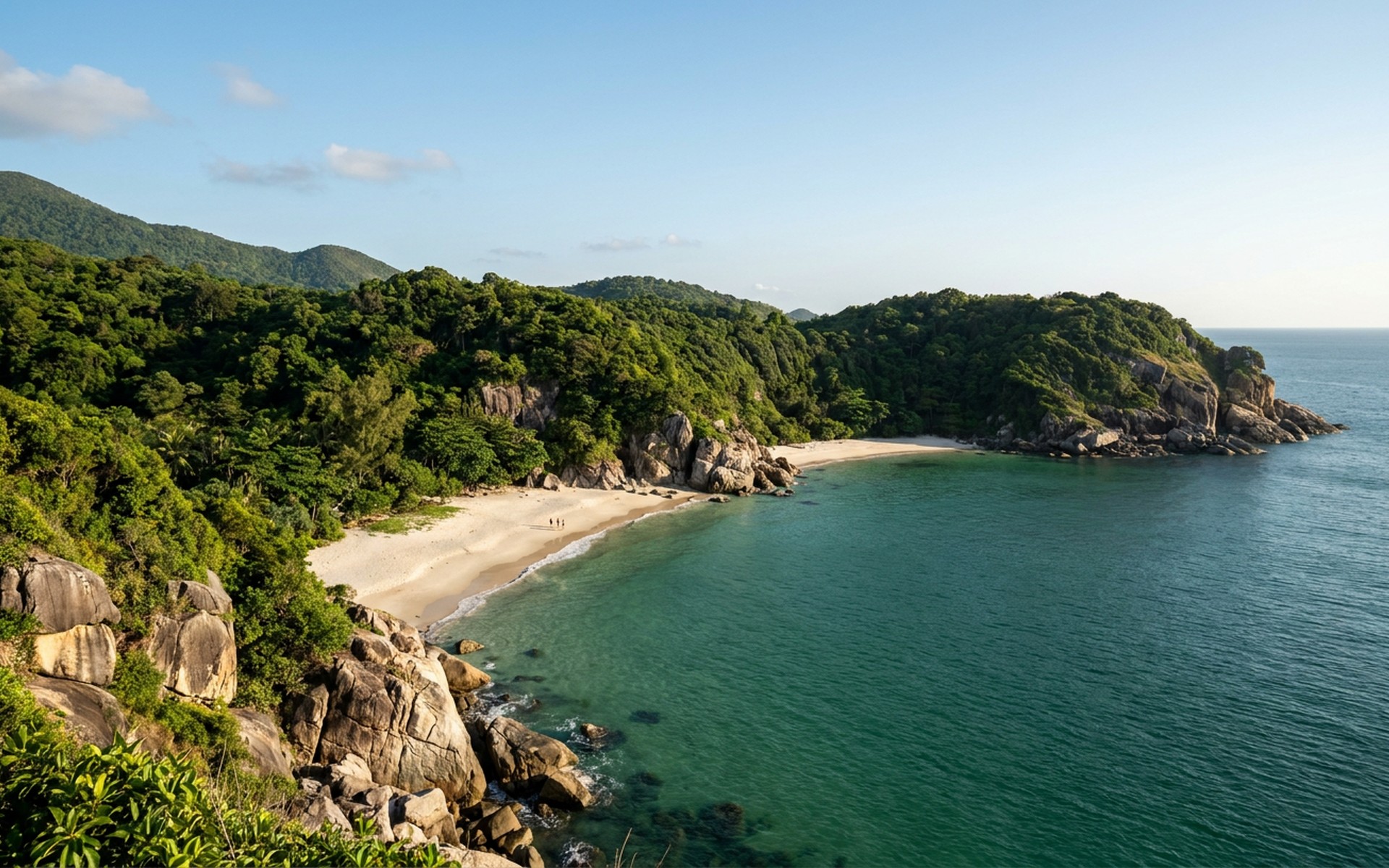Secluded crescent-shaped white sand beaches fringed by dense tropical jungle and granite cliffs, meeting emerald ocean water. at Con Dao Islands, Vietnam — original Triple VIP destination visual.