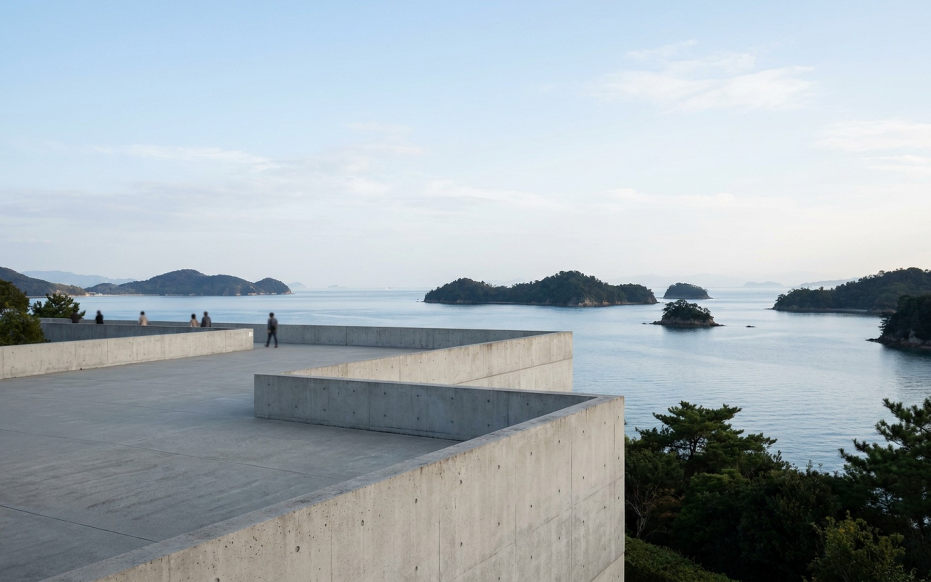 a contemporary concrete gallery terrace above a calm island sea with pine-covered islets at Naoshima, Japan — original Triple VIP destination visual.