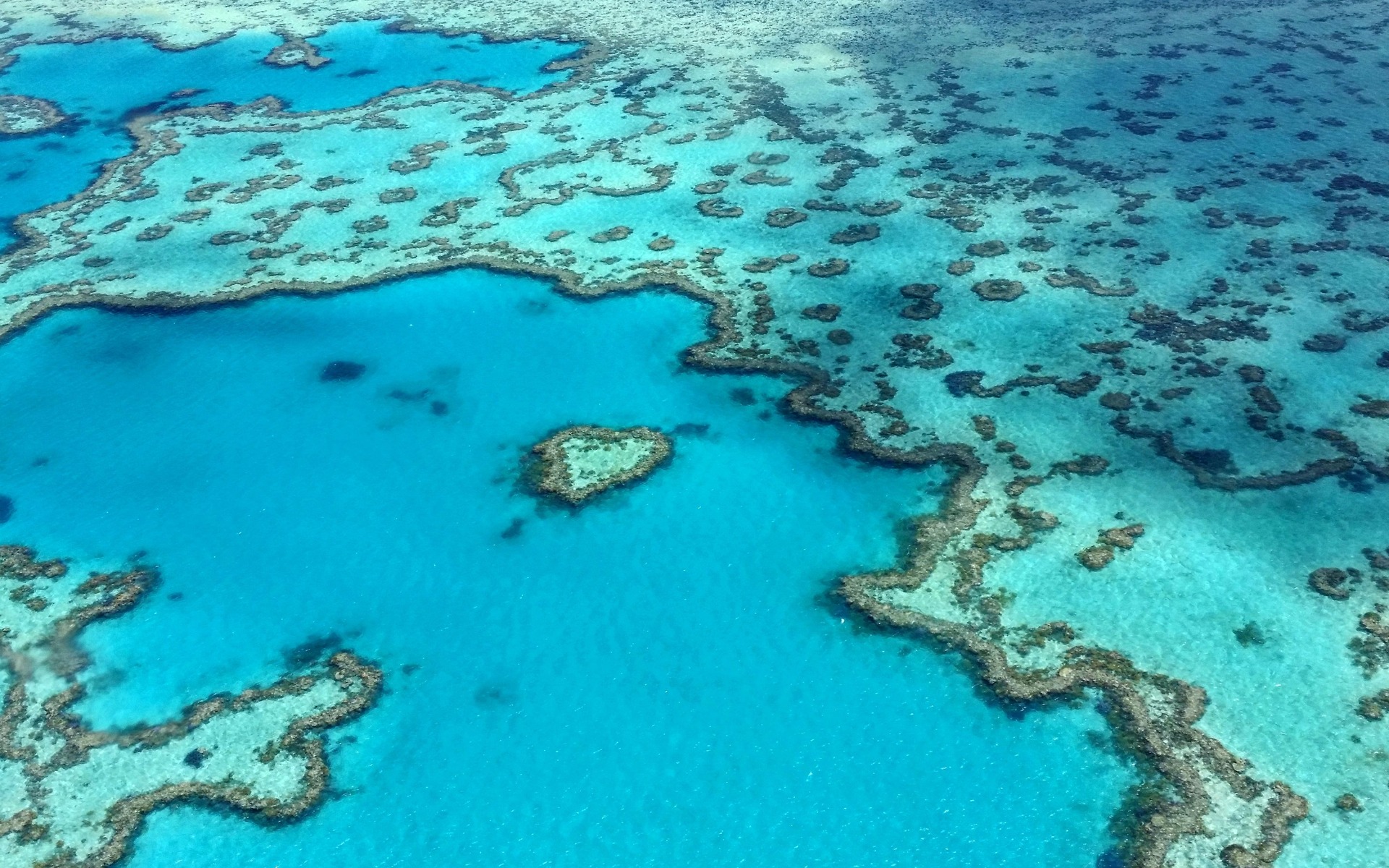 Stunning aerial photograph of the heart-shaped Great Barrier Reef in the Whitsundays, Australia.