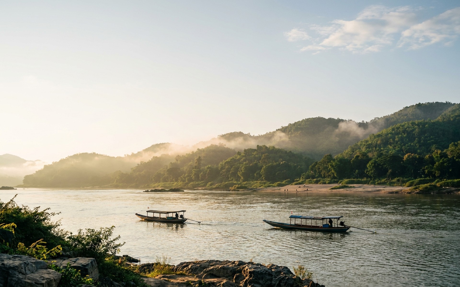 Traditional longtail boats navigating the broad Mekong River at dawn, framed by misty forested hills and a golden sunrise. at Mekong Northern Thailand, Thailand — original Triple VIP destination visual.