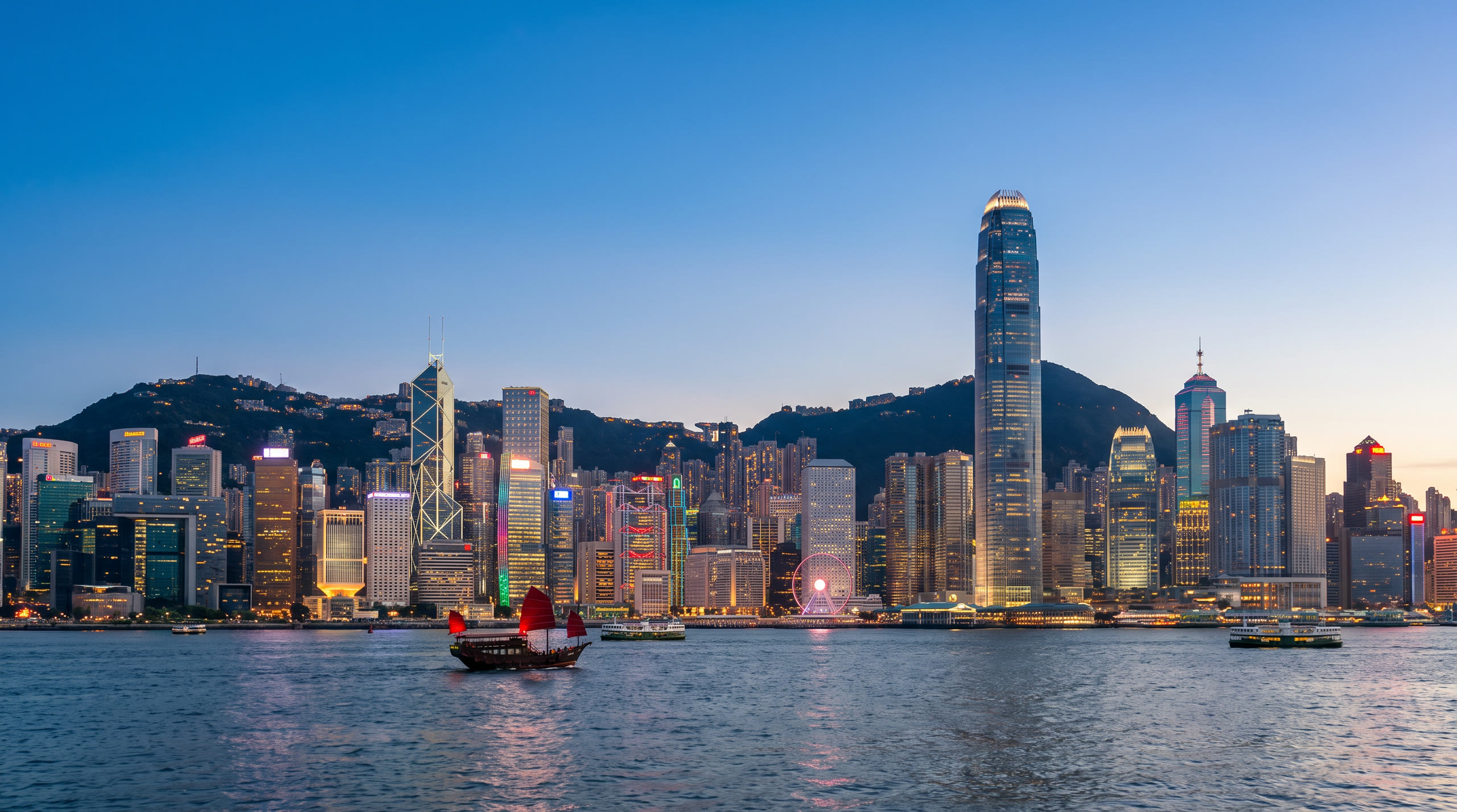 Victoria Harbour with the Central skyline below the Peak's green ridge at Hong Kong, Hong Kong, in blue hour light — original Triple VIP destination visual.