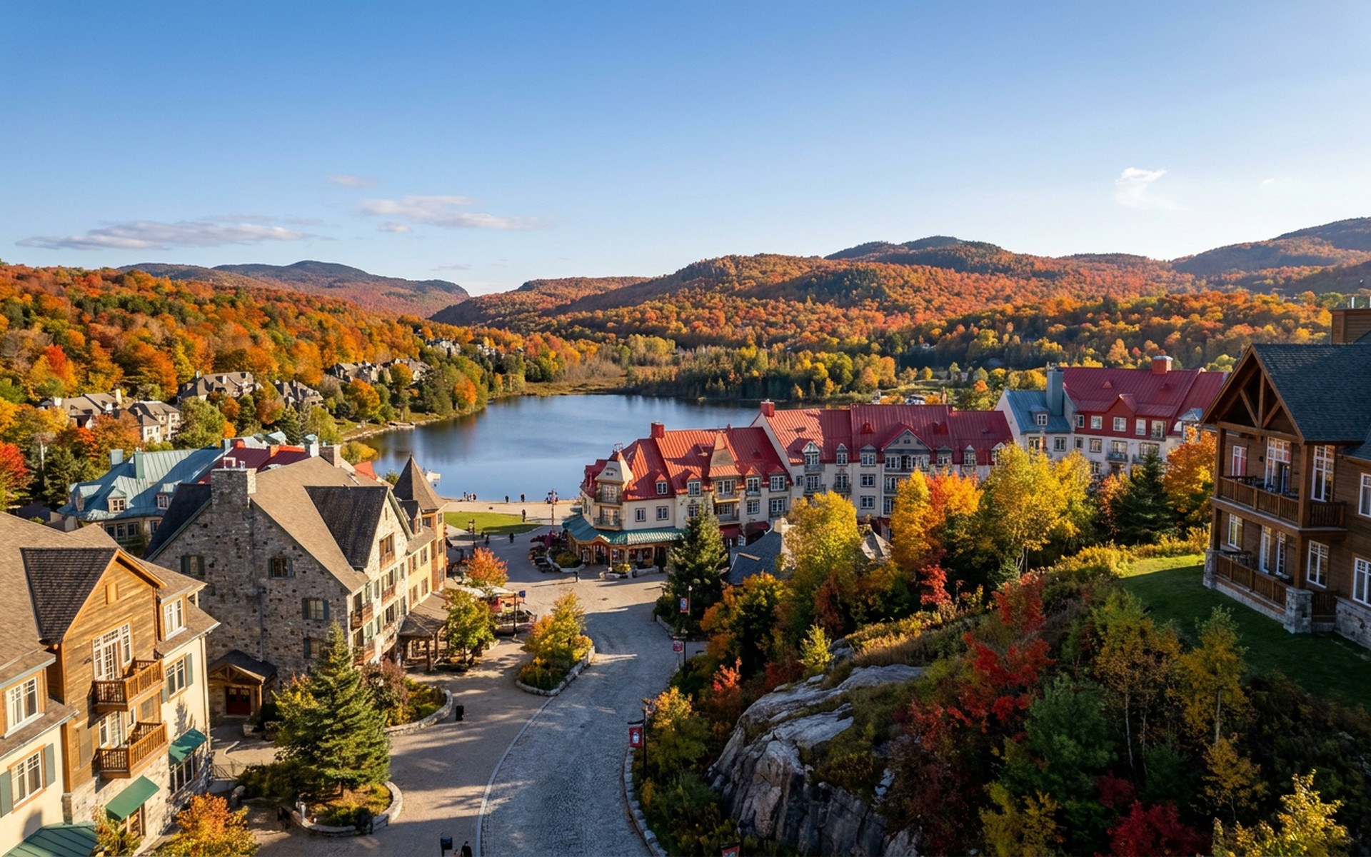 Vibrant autumn foliage covering the Laurentian Mountains surrounding Mont-Tremblant village, with a clear blue sky overhead. at Mont-Tremblant, Canada — original Triple VIP destination visual.