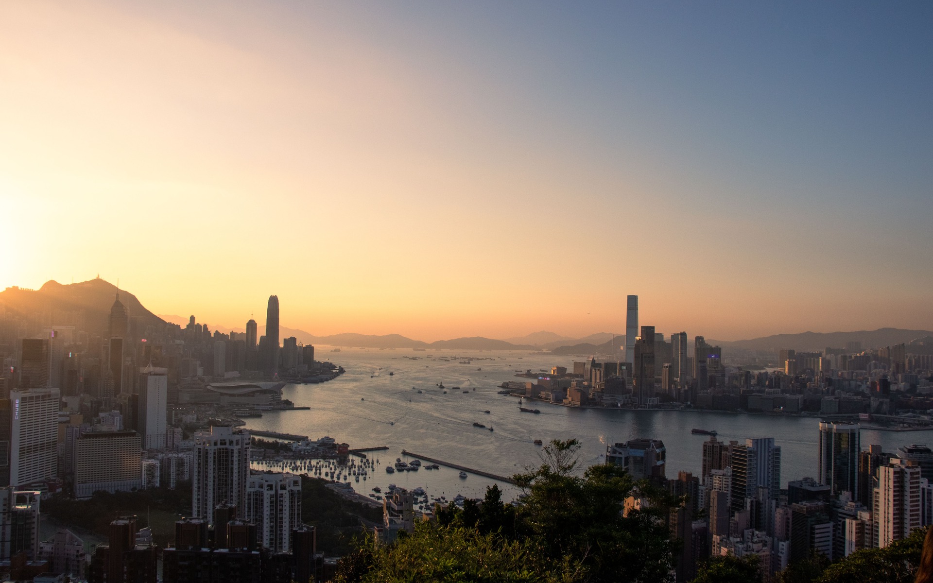 A breathtaking view of Hong Kong's skyline and harbor at sunset, capturing urban beauty.