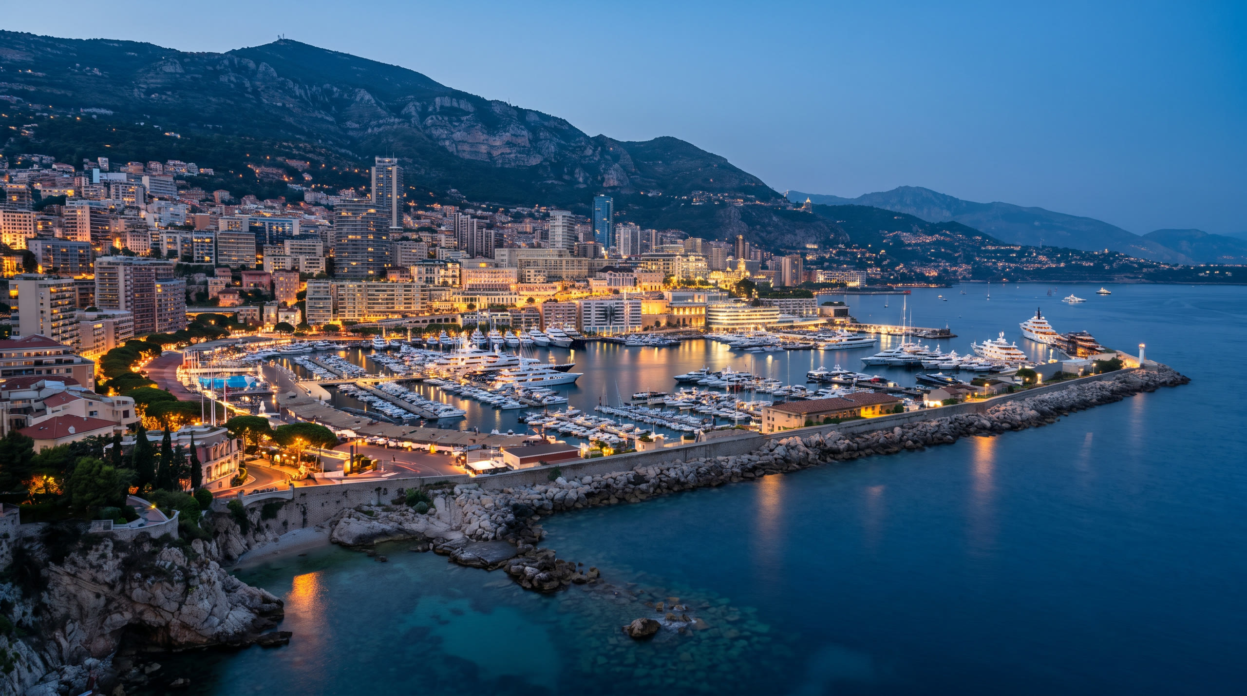 the harbour of Port Hercule packed with yachts under the Rock at Monaco, Monaco, in blue hour light — original Triple VIP destination visual.