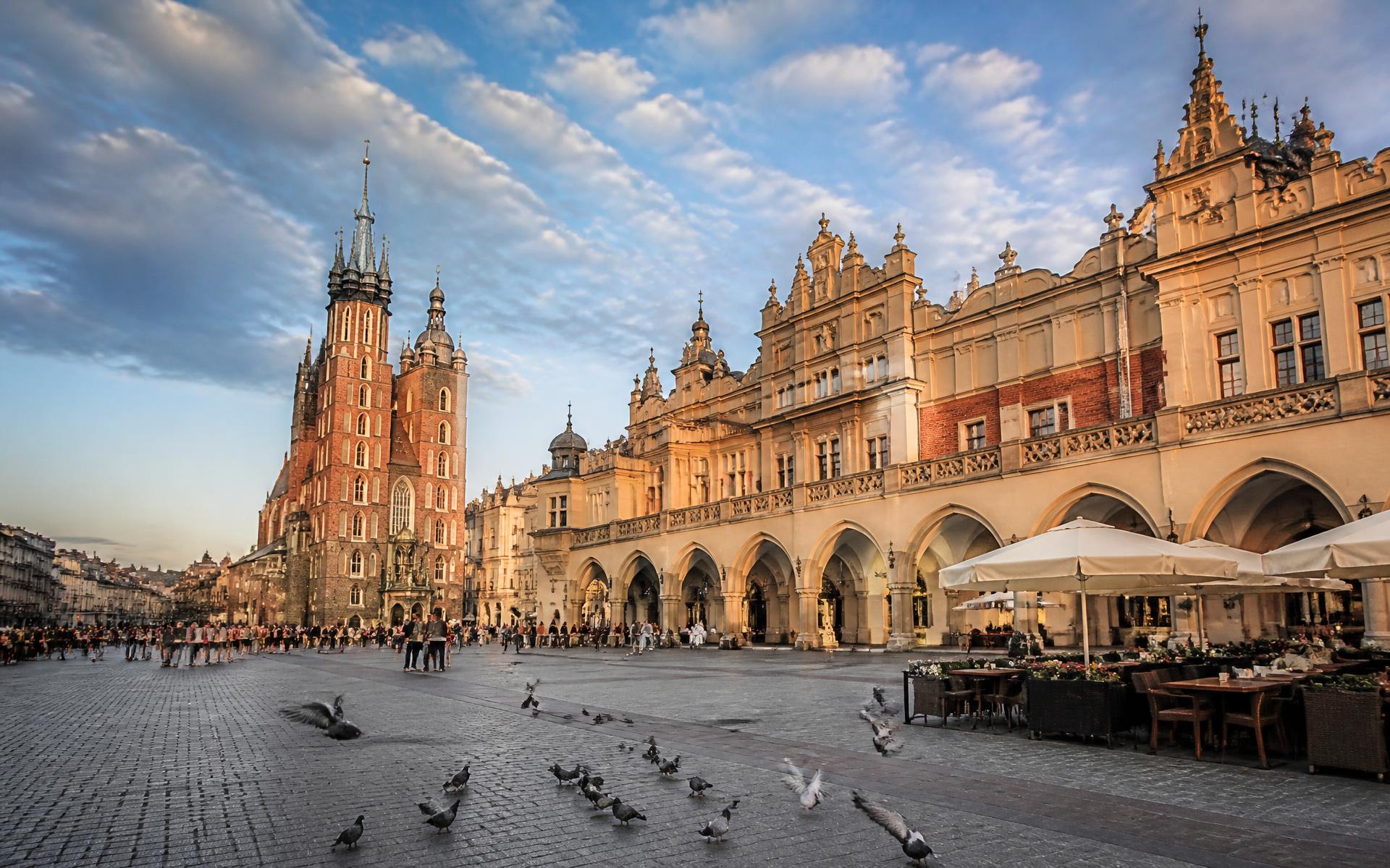Krakow's medieval main market square with the cloth hall and St Mary's Basilica at golden hour