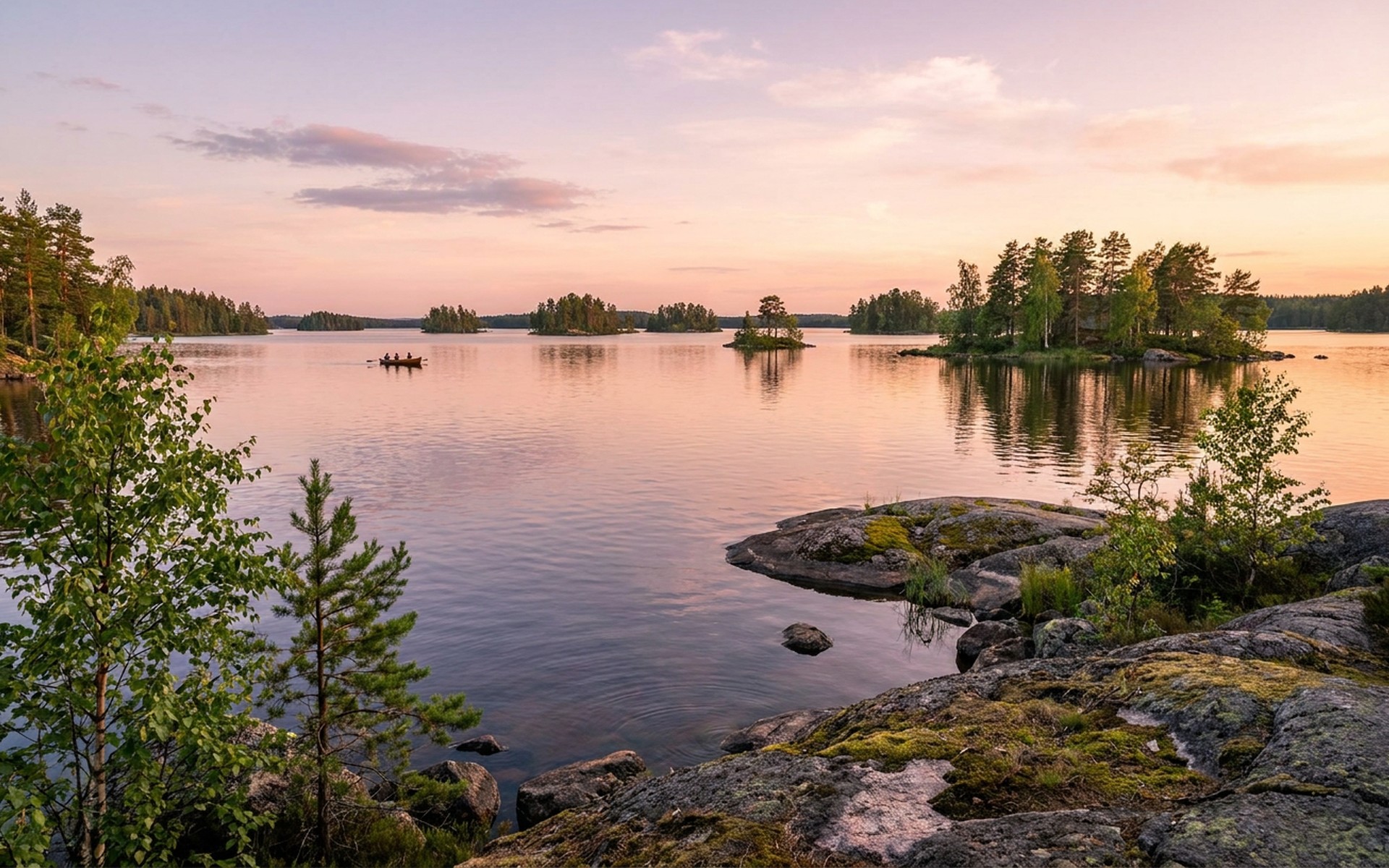 A tranquil vast lake dotted with numerous small forested islands, reflecting the soft pastel colors of a summer sunset over the untouched Finnish wilderness. at Finnish Lakeland, Finland — original Triple VIP destination visual.