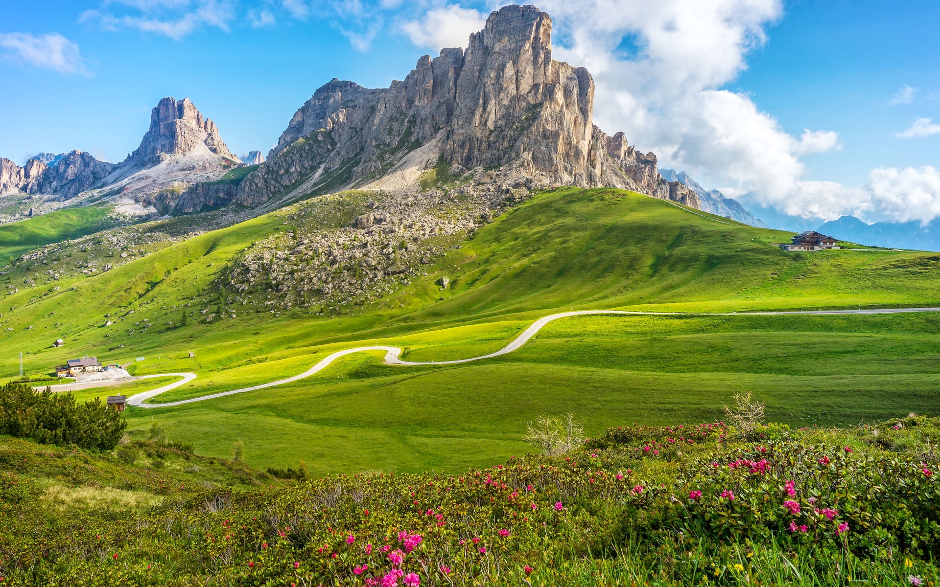 Dolomite peaks, alpine meadows and a winding mountain road in Alta Badia, Italy